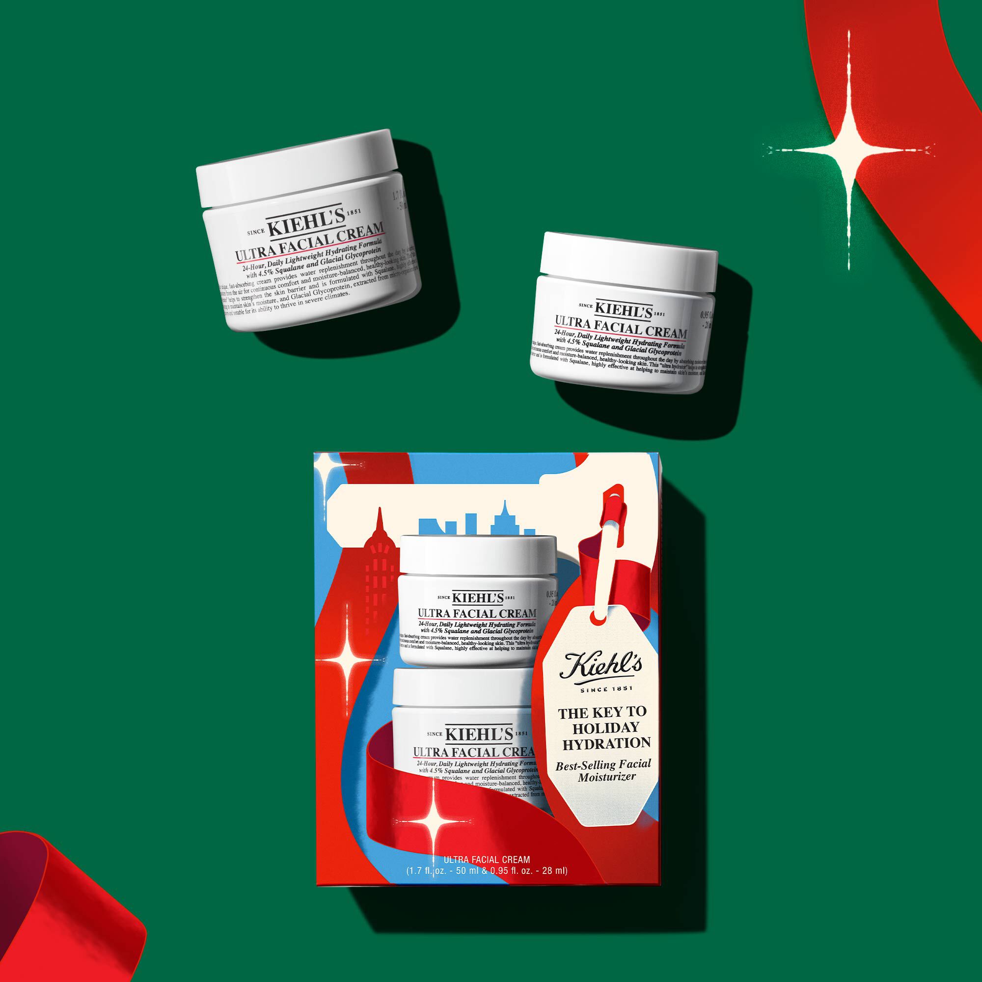 "Hydrating Holiday Hits" skincare gift set on a green background, featuring Ultra Facial Cream and Creamy Eye Treatment with Avocado in festive packaging.