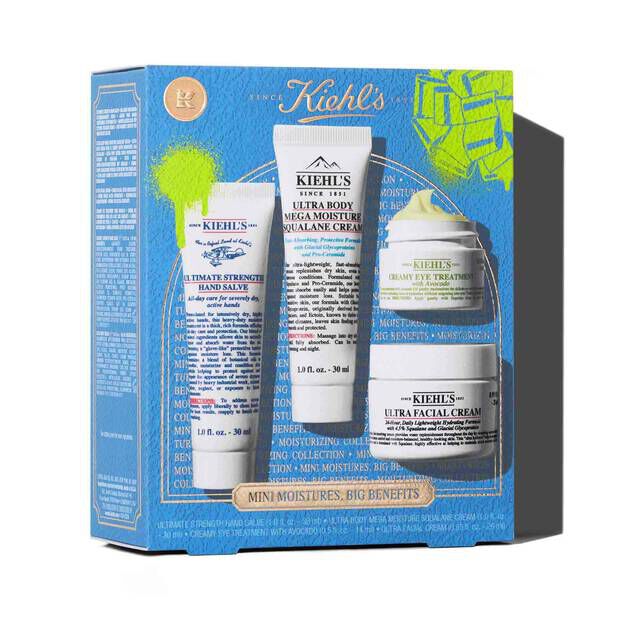 A graphic featuring a blue Kiehl’s gift box with green accents. The box contains four products: a tube of "KIEHL’S ULTIMATE STRENGTH HAND SALVE," a tube of "KIEHL’S ULTRA BODY MEGA MOISTURE SQUALANE CREAM," a jar of "KIEHL’S CREAMY EYE TREATMENT WITH AVOCADO," and a jar of "KIEHL’S ULTRA FACIAL CREAM." The box is decorated with bright green graphic paint splatters and a bow design, and features the text "MINI MOISTURES, BIG BENEFITS" at the bottom.