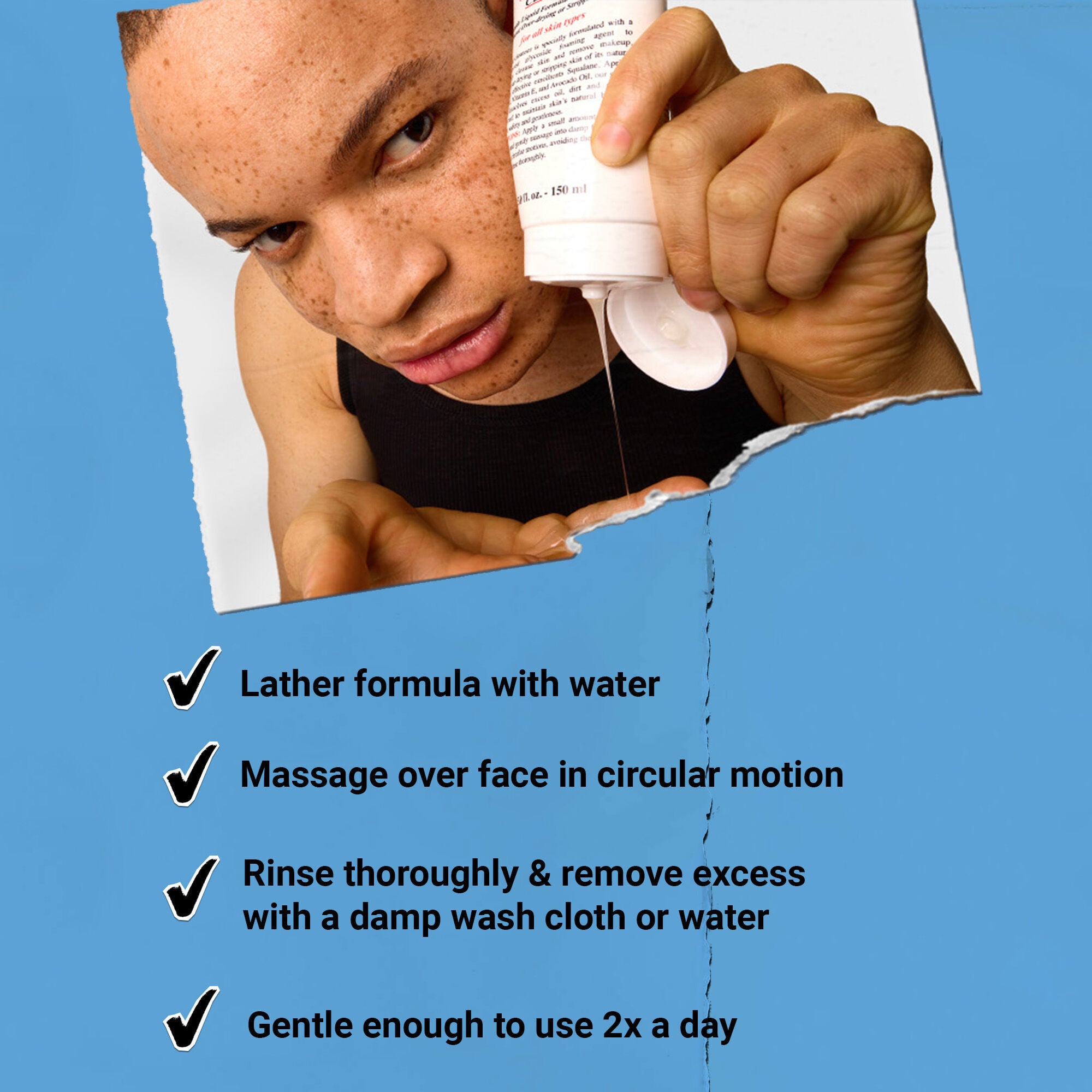 Hand holding a tube of Kiehl’s Ultra Facial Cleanser against a blue and white background.