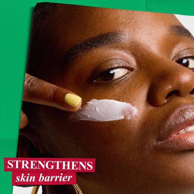 A woman applies Kiehl's Ultra Facial Cream to her face, highlighting its benefit to strengthen the skin barrier.