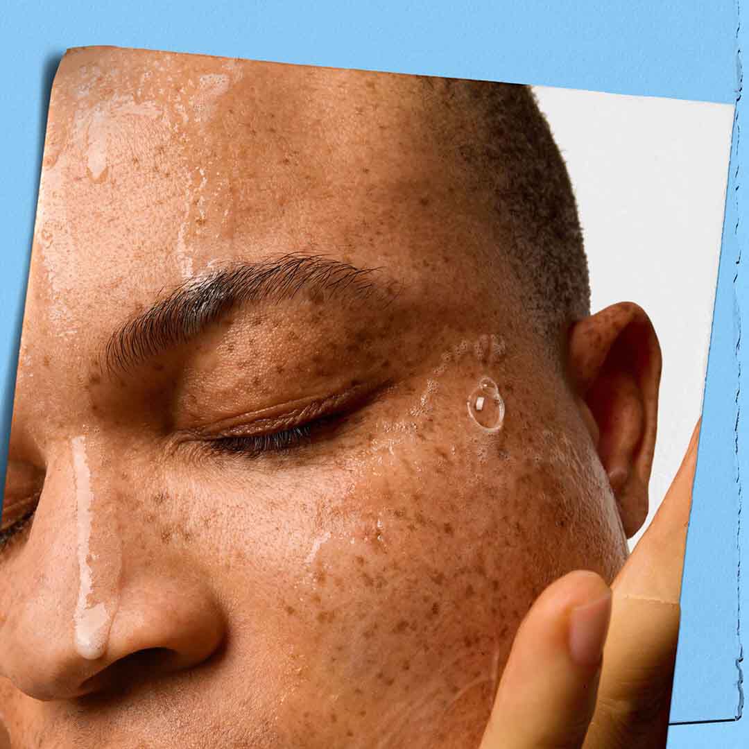 Hand demonstrating application of a foaming cleanser formula on face.